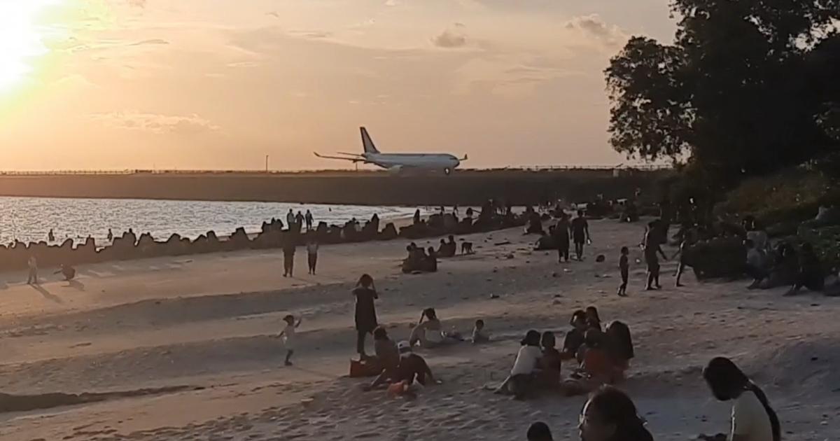 Siluet pesawat terbang di atas lautan saat matahari terbenam di Pantai Sekeh Bali, Kuta.
